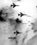 Flying under radar control with a B-66 Destroyer, Air Force F-105 Thunderchief pilots bomb a military target through low clouds over the southern panhandle of North Vietnam.  June 14, 1966.  Public Domain image by Lt. Col. Cecil J. Poss, USAF.