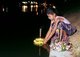 Thailand: Young girl floating a krathong on the moat in Chiang Mai's old town, Loy Krathong Festival